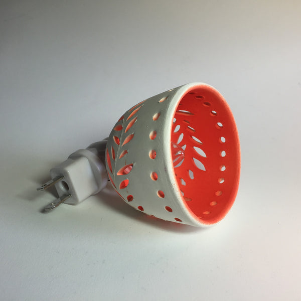 round night light in white with wavey leaf designs and yellow orange interior